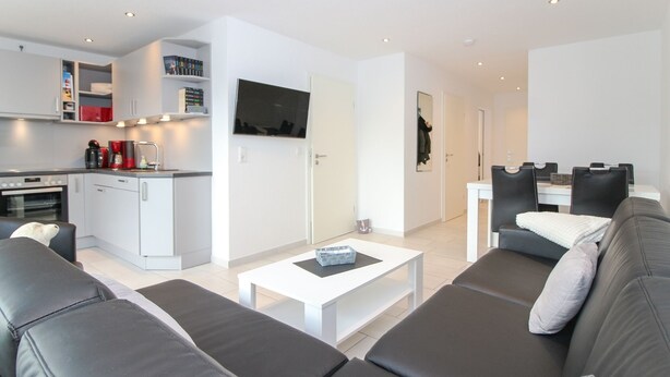 A modern apartment with a living room, kitchen, and dining area. - Bright, modern ground floor apartment for 4 people including four-legged friends (Norden)