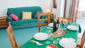A dining table set with plates, glasses, and a wooden cutting board with tomatoes. - Apollo's Terraces-Beach apartments less than 20 m from the sea! Levant (Marinella)