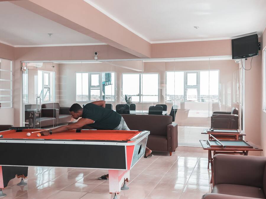 Une table de billard dans un salon moderne avec vue sur la ville.
