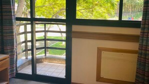 A room with a large window, a bed, and a radiator. - Hotel Canto da Ilha (Florianópolis)