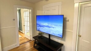 Ein Flur mit an der Wand befestigtem Fernseher, der eine verschneite Berglandschaft zeigt.