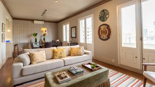A spacious living room with a sofa, coffee table, and dining area. - Tiete Classic I Stunning 3 Bedroom in Jardins (São Paulo)