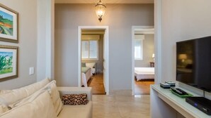 A modern living room with a sofa, a television, and a hallway leading to another room. - Tiete Classic I Stunning 3 Bedroom in Jardins (São Paulo)