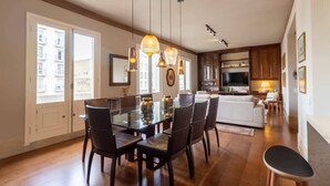 A spacious dining area with a glass table and chairs, wooden cabinets, and pendant lighting. - Tiete Classic I Stunning 3 Bedroom in Jardins (São Paulo)