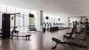 Ein modernes Fitnessstudio mit unterschiedlichen Trainingsgeräten, großen Fenstern und großzügiger Gestaltung.