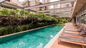 Une piscine sur le toit, agrémentée de chaises longues et de plantes.