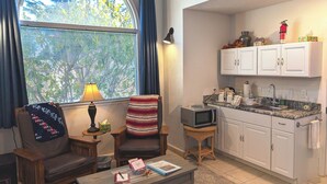 A compact living space with a dining area, kitchenette, and a large window with blinds. - Sparkling Clean, Private & Quiet! Amazing Ocean Views [7] (Brookings)