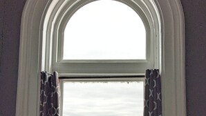A window with a view of a building with a clock tower. - Tanner Bldg Apt 7 - 2 bedroom 1 king & 1 queen (Downtown) (Bay City)