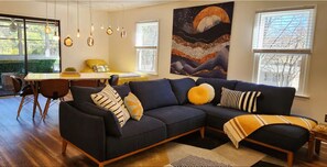 Relax in a stylish living room with a sofa, dining area, and large window.