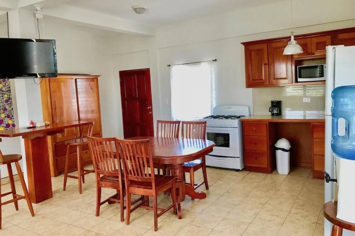A kitchen with wooden cabinets, a stove, a microwave, and a water dispenser.