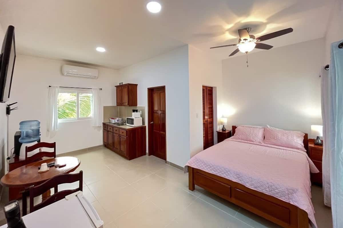 A bedroom with a bed, bedside tables, a ceiling fan, and a window.