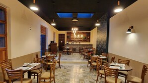 A restaurant with multiple tables and chairs, a patterned floor, and a ceiling with skylights. - Hotel Úrsula Concept (Querétaro)
