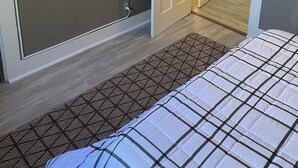A bedroom with a bed, a door, a wall-mounted tree decoration, and a patterned rug. - 2b apt loft Downtown Ipswich (Ipswich)