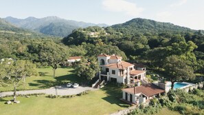 A large, multi-story villa with a swimming pool, surrounded by lush greenery and mountains. - Hotel Rincon del Cerro (Villa San Lorenzo)