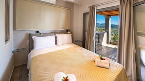 Camera d'albergo con un letto grande, vista sull'esterno e un balcone con una pergola.