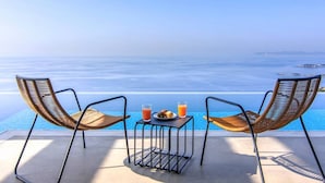 A poolside seating area with two chairs and a table, overlooking a clear blue sea. - Villa Blue Ionian - Syvota (Igoumenitsa)