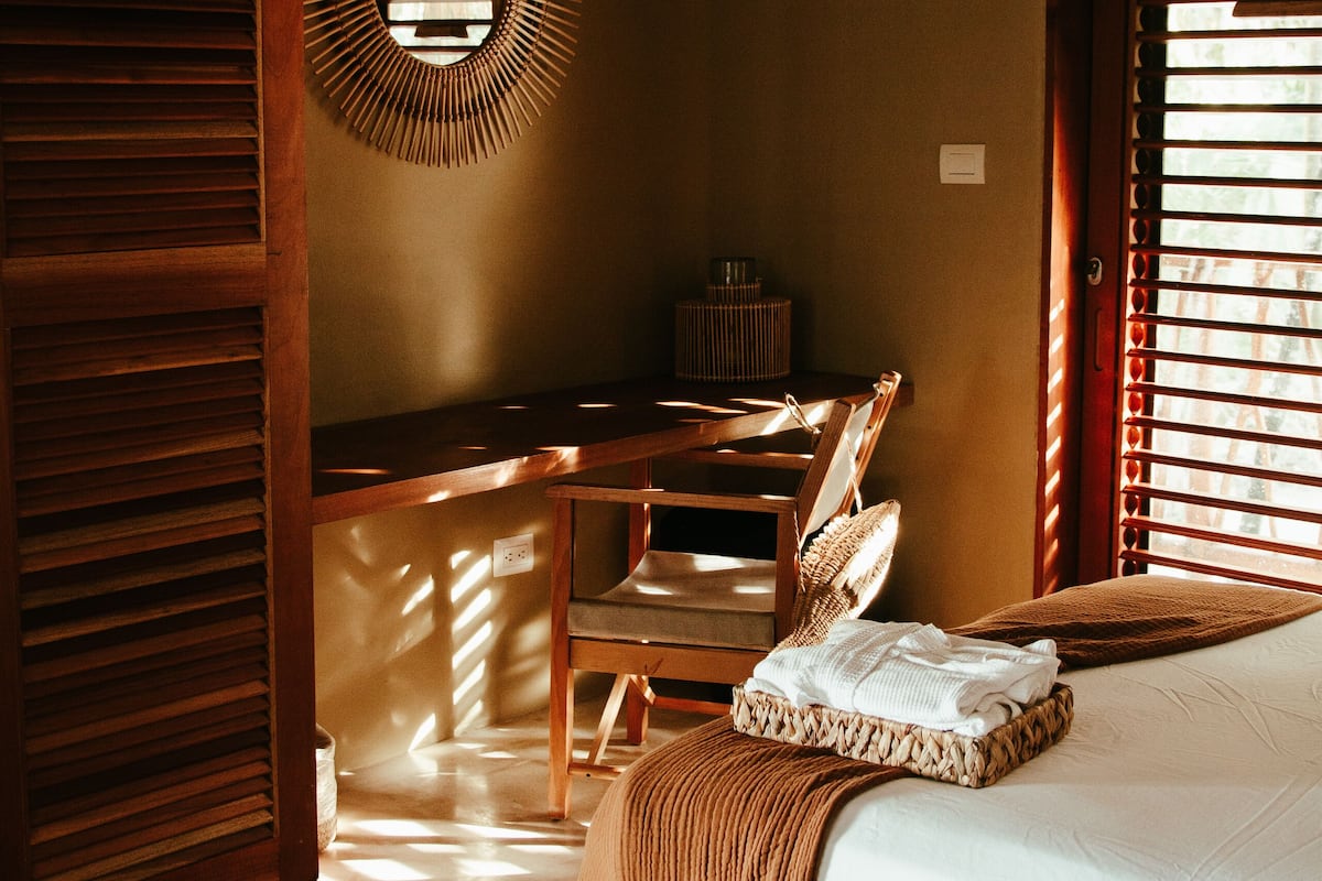 A bedroom with a bed, a desk, and a chair.