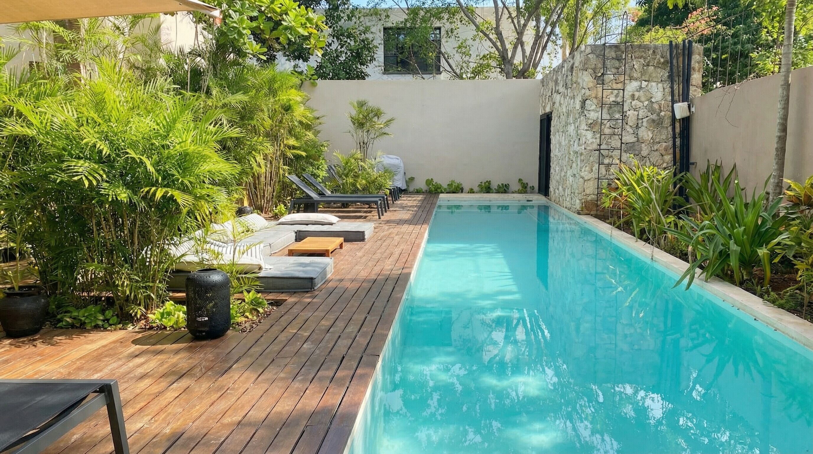 Una piscina al aire libre, sombrillas, tumbonas