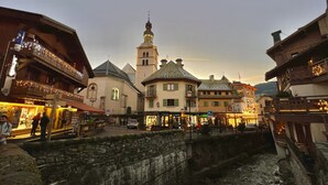 Une place historique, dominée par un imposant clocher d’église, bordée de rues pavées et entourée de bâtiments traditionnels.