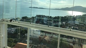 Un balcón con vista a un cuerpo de agua, edificios y una isla distante.