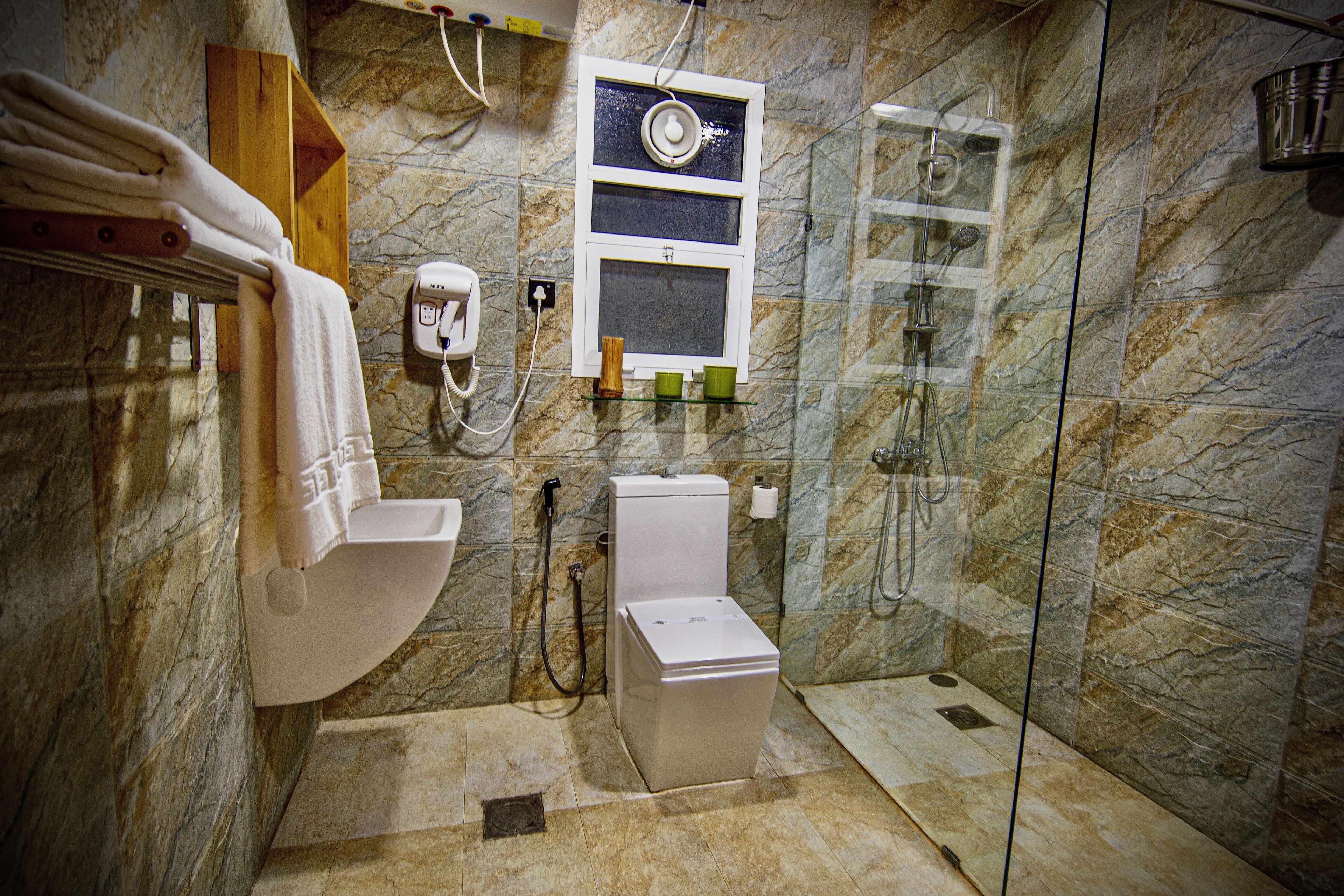 A bathroom with a toilet, bidet, and a glass-enclosed shower area.