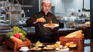 A chef in a professional kitchen with various dishes and ingredients on the counter. - Four Points by Sheraton Chongqing, Yongchuan (Chongqing)