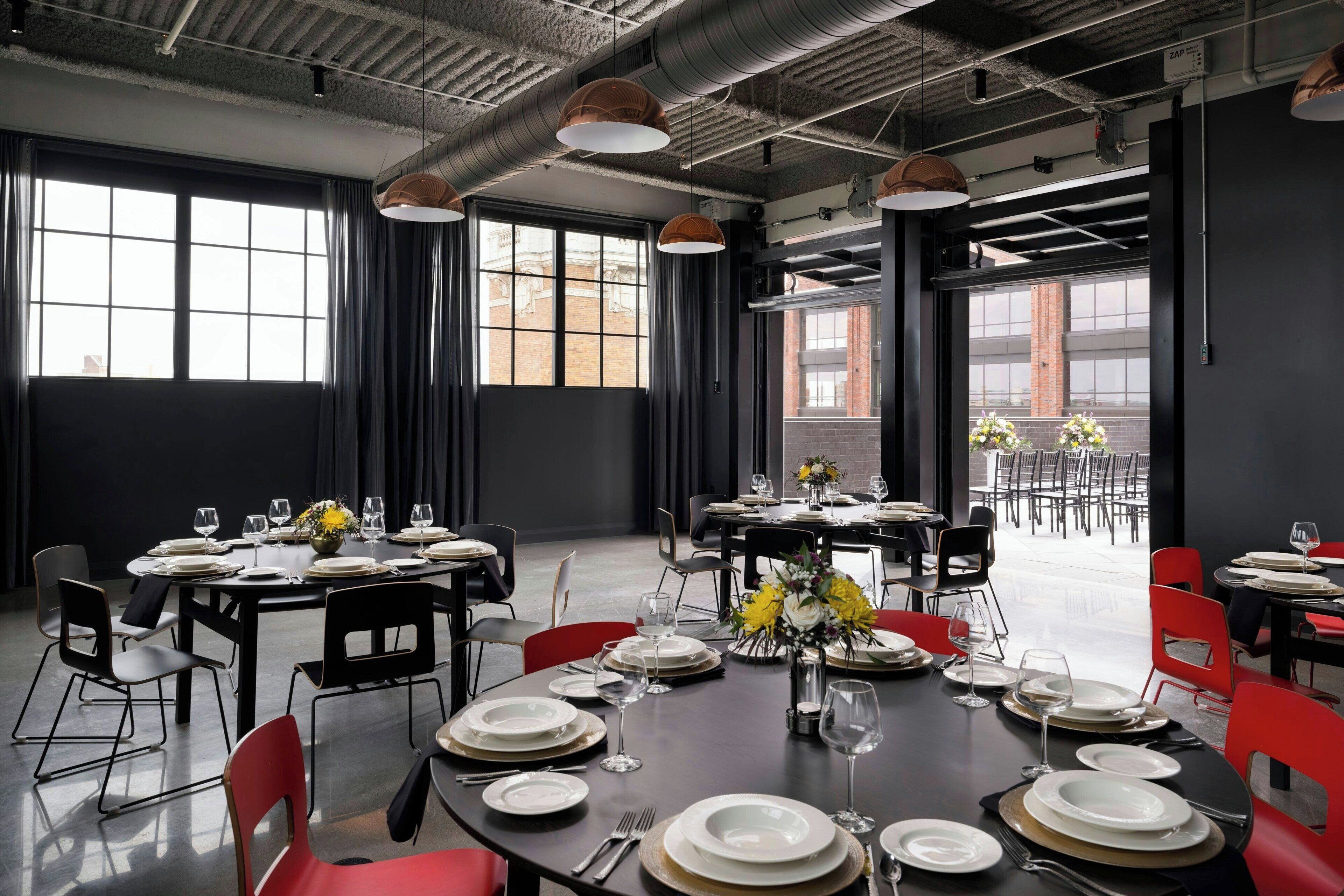 A dining area with tables set for service, large windows, and a view of the outside.