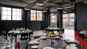 A dining area with tables set for service, large windows, and a view of the outside.