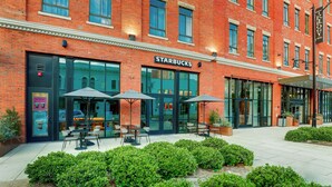 Ein Starbucks mit Außenbereich und einer Fassade aus Ziegelsteinen.
