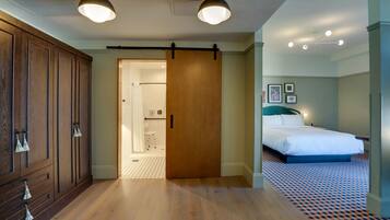 Una habitación de hotel con un armario de madera, una cama con cabecera azul y un suelo estampado.