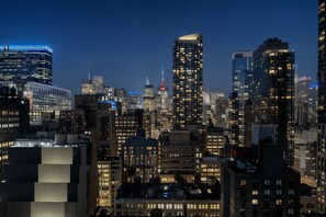 A cityscape at night with illuminated buildings and a prominent tower in the background. - Aloft by Marriott New York Chelsea (New York)