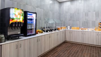 Uma cozinha moderna com uma máquina de café, uma geladeira e diversos alimentos sobre o balcão.