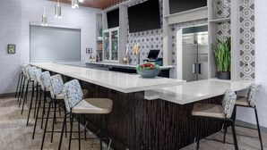A modern kitchen with a central island, bar stools, a large refrigerator, and a patterned backsplash. - TownePlace by Marriott Suites Buckeye Verrado (Buckeye)
