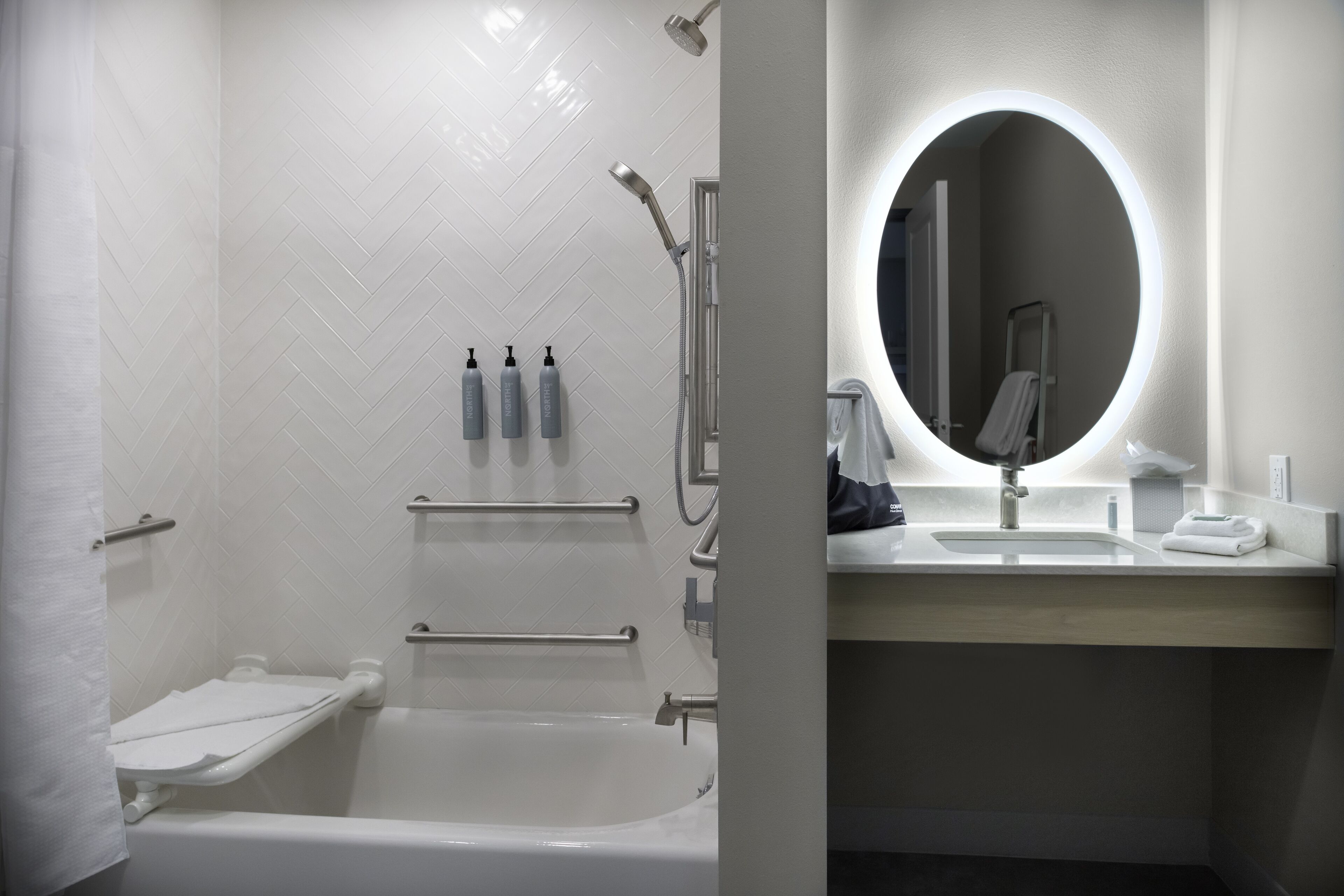 Un baño moderno con ducha, bañera y tocador con espejo.