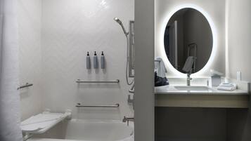 Un baño moderno con ducha, bañera y tocador con espejo.