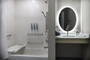 Un baño moderno con ducha, bañera y tocador con espejo.