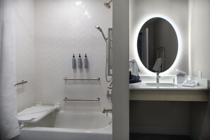 Une salle de bain moderne équipée d’une douche, d’une baignoire et d’un meuble-lavabo avec un miroir.