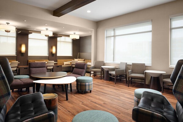 A modern lounge area with multiple seating options including sofas, armchairs, and ottomans, arranged around tables and a central coffee table. - Residence Inn by Marriott Rochester Mayo Clinic Area South (Rochester)