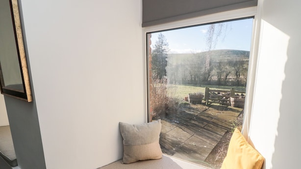 Una habitación con un ventanal grande, una cama y vistas a un jardín.