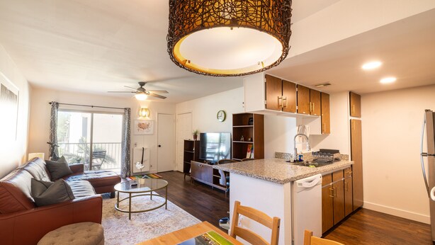 Un apartamento moderno con sala de estar, comedor, cocina y balcón.