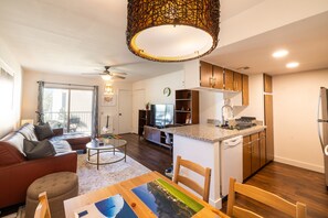 Eine moderne Wohnung mit Wohnzimmer, Essbereich, Küche und Balkon.