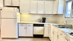 A kitchen with white cabinets, a dishwasher, a coffee maker, and a sink. - Spacious House short walk to Bills Stadium (Orchard Park)