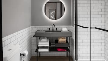 A modern bathroom with a round mirror, a sink, and a shower.