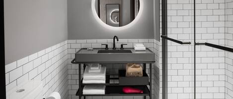 Une salle de bain moderne avec un grand miroir rond, un lavabo et une douche.