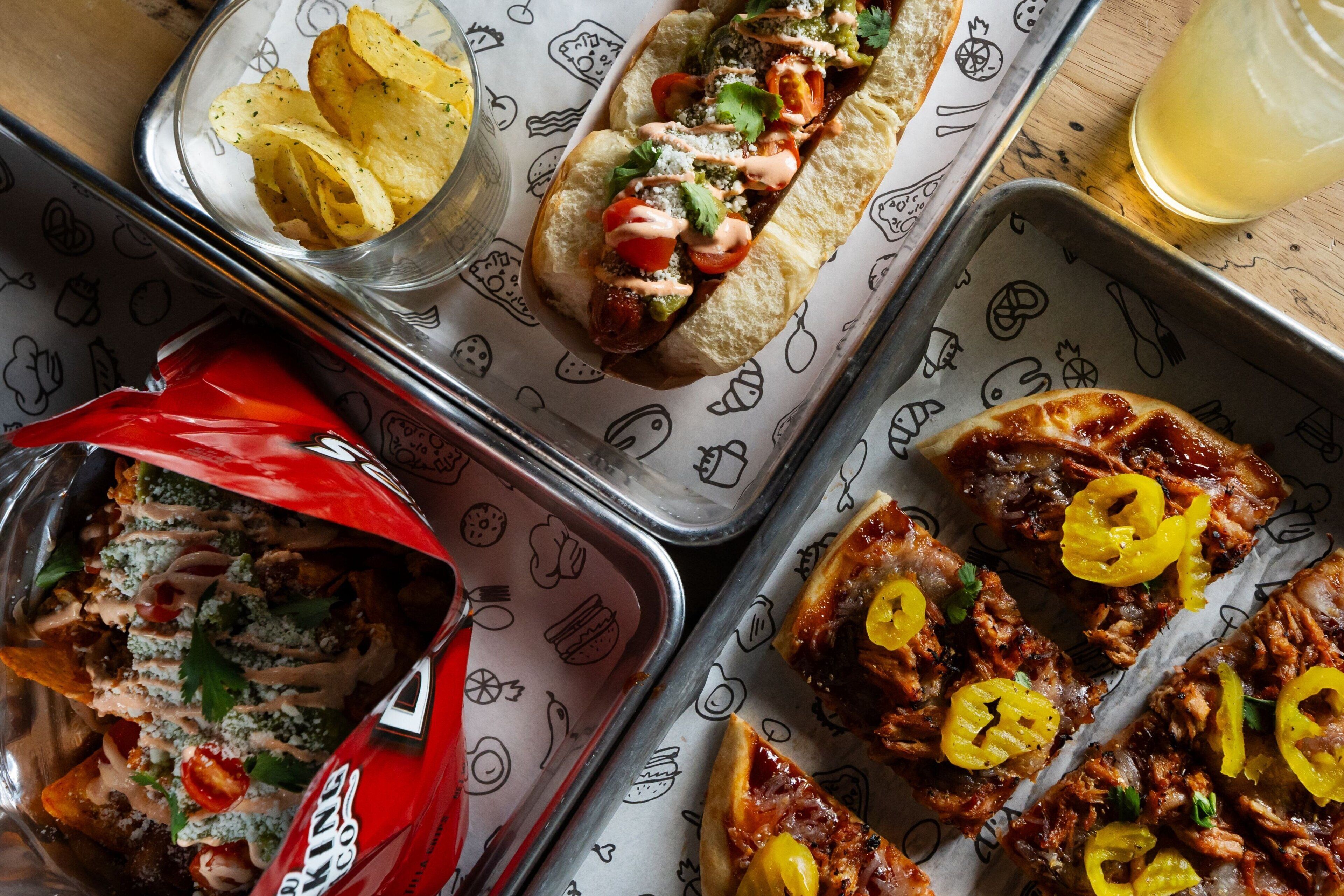 A tray with various food items including a sandwich, chips, and a drink.