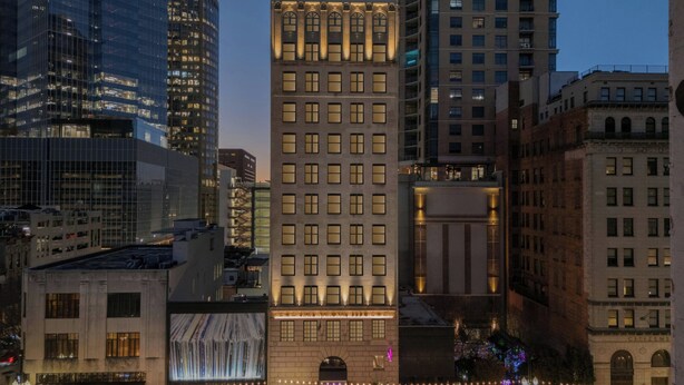 A multi-story building with a classic architectural style, featuring a central entrance with a large arched doorway and a series of windows on each floor. - Moxy Houston Downtown (Houston)