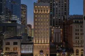 Un edificio de varios pisos con un estilo arquitectónico clásico, que presenta una entrada central con un gran arco y una serie de ventanas en cada planta.