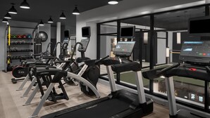 A modern gym with treadmills, weight machines, and cardio equipment. - Moxy Houston Downtown (Houston)