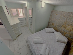 A bedroom with a bed, a dresser, a vanity, and a window. - Loft Barra da Fortaleza - Piscina (Florianópolis)