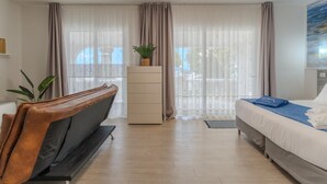 A modern hotel room with a bed, a desk, a chair, and a large window with curtains. - Villa Blanca Callao Salvaje. First line by the sea (Callao Salvaje)